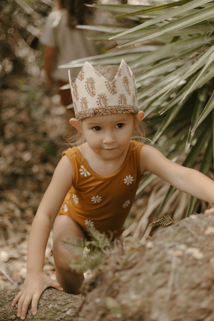 girl-climbing-tree-in-ochre-daisy-swimsuit-with-crown